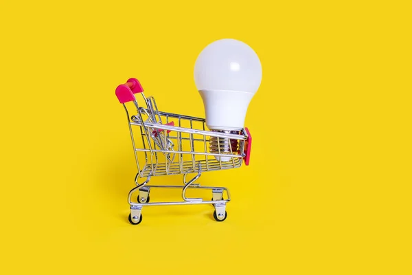 Small Shopping Cart Energy Saving Light Bulb Yellow Background Favorable — Photo