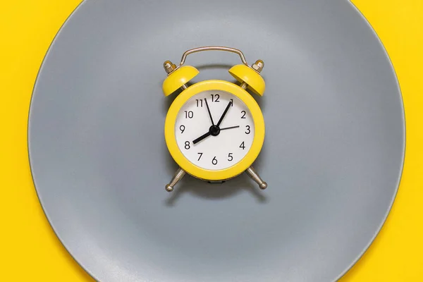 Ένα Κίτρινο Ξυπνητήρι Βρίσκεται Ένα Πιάτο Κίτρινο Φόντο Έννοια Της — Φωτογραφία Αρχείου