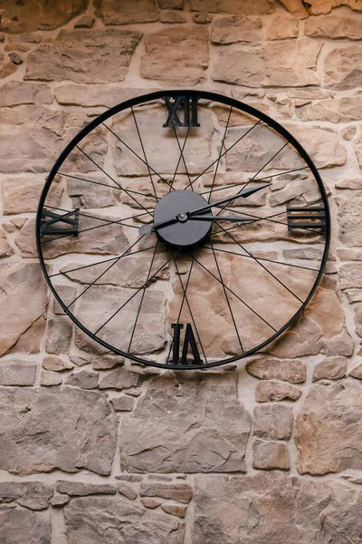 Μαύρο Ρολόι Μορφή Τροχού Ποδηλάτου Στο Φόντο Ενός Πέτρινου Τοίχου — Φωτογραφία Αρχείου