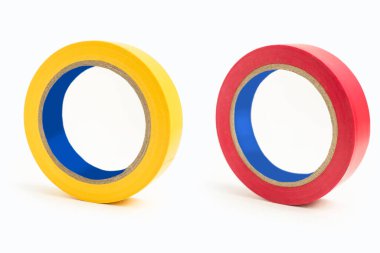 Beyaz arka planda kırmızı ve sarı elektrik bandı lekesi. Elektrik kablolarını izole etmek için kullanılan bir alet. İzole edilmiş beyaz arka planda kırmızı ve sarı kauçuk yapıştırıcı bant.