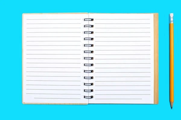 青い背景に結合と黄色の鉛筆で開いたノートブック 空白のシートでメモ帳を開きます テキストのための無料スペース デザイン用のブランクノートブックページ — ストック写真