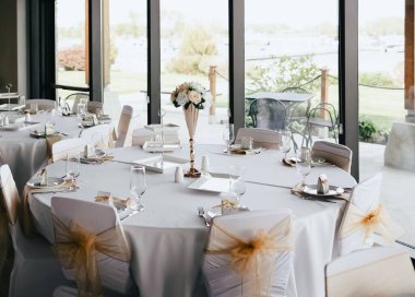 Çiçeklerle süslenmiş bir restoranda servis masası. Çiçek ve kurdele şeklinde dekorasyonu olan bir restoran. Düğün ve resepsiyona hazırlanıyorum.