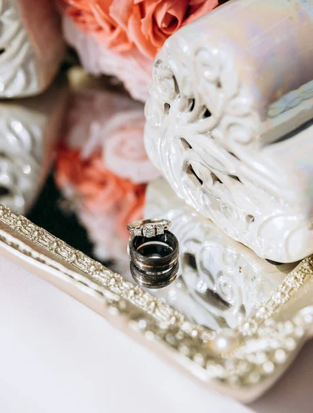 光彩夺目的结婚戒指是由黄金和钻石做成的 在反光的表面上 新娘和新郎用豪华戒指形式的婚礼饰物 镶有宝石的结婚戒指 — 图库照片