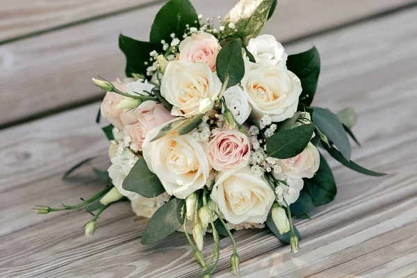 婚礼花束白色和粉红色的玫瑰在木制长椅上 美丽的新娘玫瑰花束的特写 新娘花束形式的传统婚礼饰物 — 图库照片