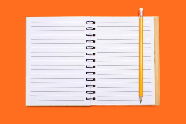 オレンジ色の背景にバインダーと黄色の鉛筆で開いたノート 上部ビューに空白のシートを含むメモ帳を開きます テキストのための無料スペース デザインに使用する準備ができて空白のノートブックページ — ストック写真