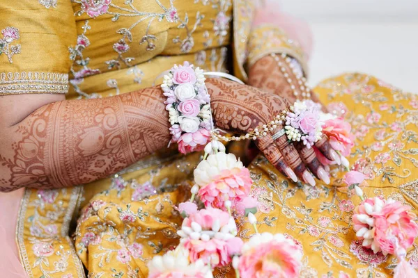 The hands of an Indian bride are decorated with Indian-style henna flowers and designs. Bride\'s hands close-up with patterns and ornaments in traditional Indian style