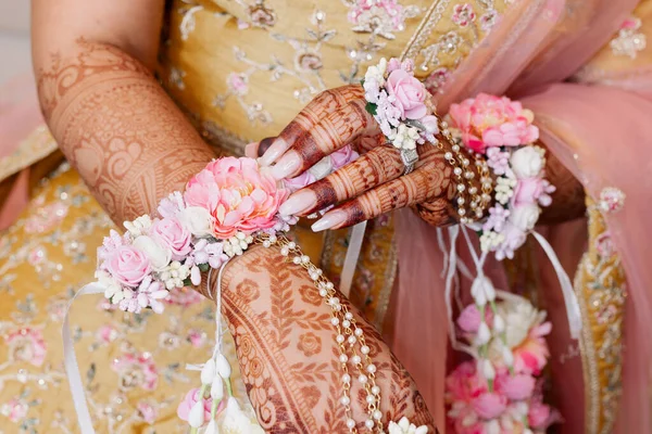 The hands of an Indian bride are decorated with Indian-style henna flowers and patterns. Hands of the bride close-up with patterns and ornaments in traditional Indian style top view