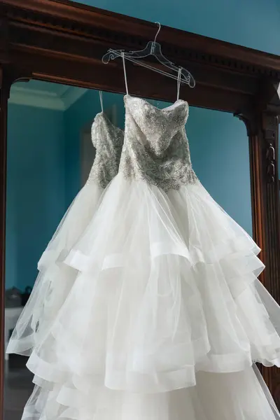 Das Brautkleid Der Braut Hängt Auf Einem Kleiderbügel Vor Dem — Stockfoto