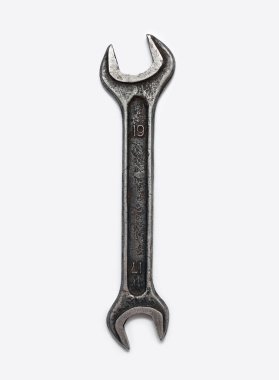 İngiliz anahtarı dikey beyaz arkaplanda izole edilmiş. Merkezde bir el aleti üst görünümü, insan yok. Eski ve kirli metal anahtar.