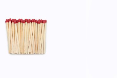Beyaz arka planda izole edilmiş kibrit kutusu olmayan kibrit kutuları kenarda bulunur. Kırmızı kibritlerin yakın plan görüntüsü ve metin için boşluk. Kutusuz birçok kibrit yan yana.