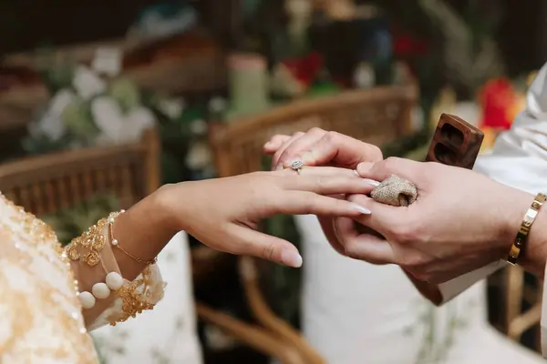 Damat düğün töreninde yüzüğü gelinin parmağına takar. Hint düğünü ve düğün töreninde yüzük takmak. Gelinin ve damadın elleri, yaklaşın.