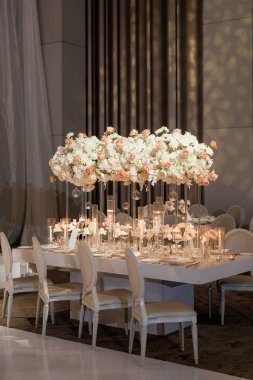 Şenlikli bir akşam yemeği ya da bir restoranda düğün için masa hazırlamak. Çiçekler ve mumlarla dolu şenlikli bir etkinlikte lüks bir masa. Bir restoranda romantik bir ortam ya da çatal bıçaklı şık bir yer.