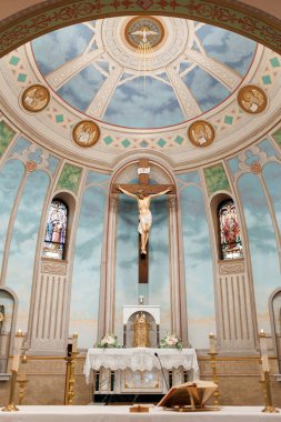 Kilisenin içinde İsa 'nın kubbe altında haç ve figürü var. İçerideki Hıristiyan kilisesinin fotoğrafı. Gündüz vakti vitraylı camlı. Din ve inanç, Katoliklik