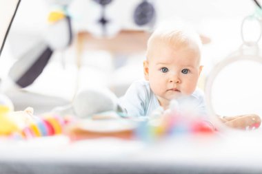 Bebek oyuncaklarıyla oynayan sevimli bir çocuk. Bebek aktivitesi ve çocuk gelişimi için oyun merkezi. Evde oynayan bebek..