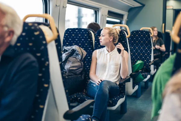 電車で旅行している間トラフ ウィンドウを探している若い女性 — ストック写真