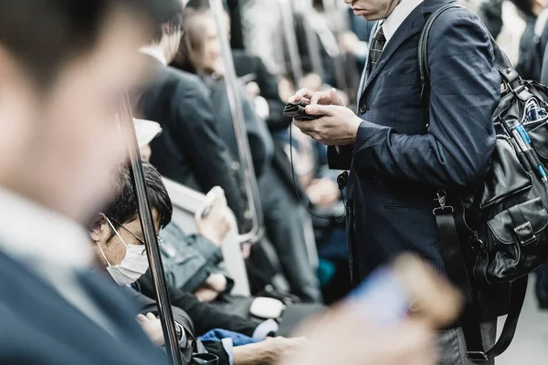 携帯電話を使用して座席やビジネスマンに乗客と近代的な東京メトロのインテリア 公共交通機関を利用して通勤する法人の方 水平構成 — ストック写真