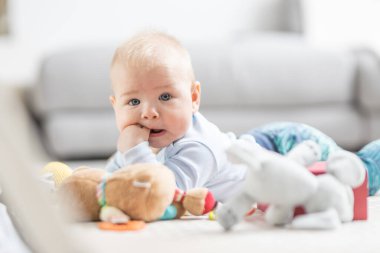 Bebek oyuncaklarıyla oynayan sevimli bir çocuk. Bebek aktivitesi ve çocuk gelişimi için oyun merkezi. Evde oynayan bebek..