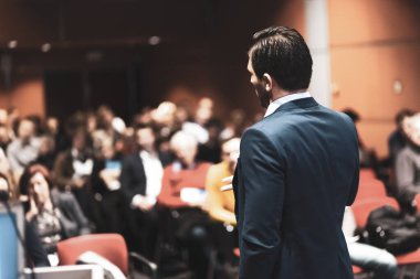 Sözcü kurumsal İş Konferansı hakkında bir konuşma yapacak. Konferans salonundaki izleyiciler. İş ve Girişimcilik etkinliği.
