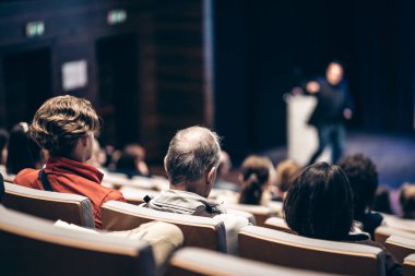 Sözcü, iş konferansında konferans salonunda konuşma yapacak. Konferans salonundaki tanınmayan insanların arka görüntüsü. İş ve girişimcilik kavramı
