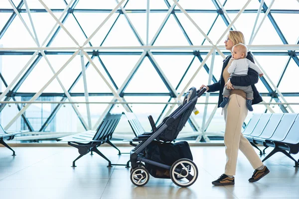 Mother Carying His Infant Baby Boy Child Pushing Stroller Airport — Stockfoto