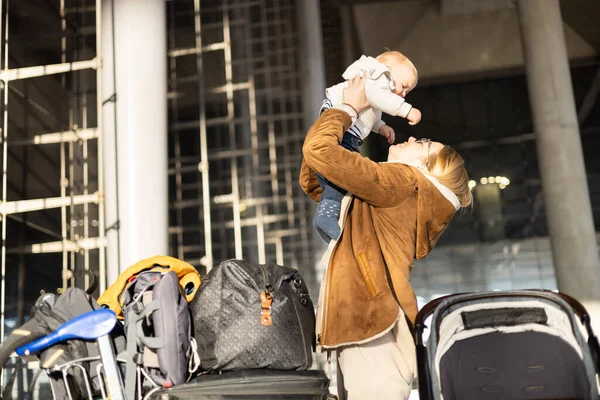 空港のターミナル駅の前で再会した後 お母さんは喜んで彼の幼い男の子の子供を空中に持ち上げます 赤ちゃん旅行のコンセプト — ストック写真