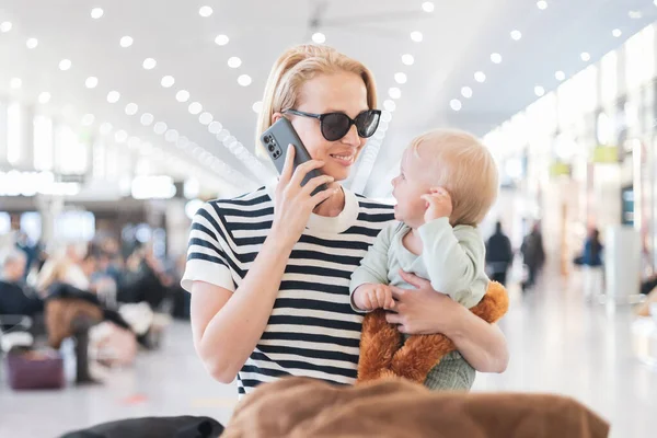 Мать Разговаривает Мобильному Телефону Время Путешествия Ребенком Держа Младенца Терминале — стоковое фото