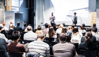 Sözcü, iş konferansında konferans salonunda konuşma yapacak. Konferans salonundaki izleyiciler. İş ve Girişimcilik konsepti. Seyirciler arasındaki tanınmayan kişilere odaklanın..