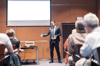 Sözcü iş toplantısında bir konuşma yapacak. Konferans salonunda dinleyiciler. İşletme ve girişimcilik. Boşluğu beyaz tahtaya kopyala.