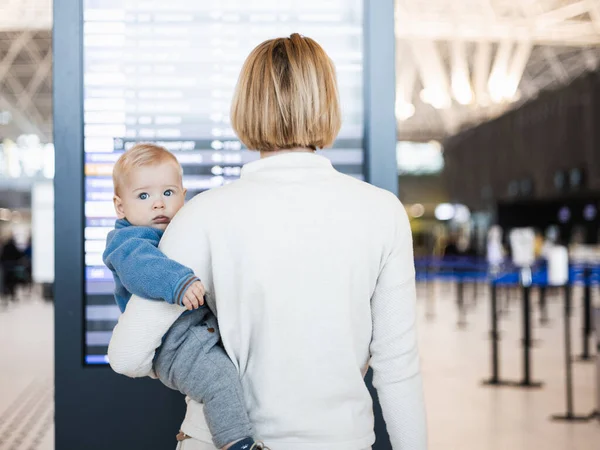 Matka Podróżująca Dzieckiem Trzymająca Małego Chłopca Lotnisku Sprawdzająca Rozkład Lotów — Zdjęcie stockowe