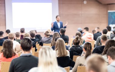 Sözcü, iş konferansında konferans salonunda konuşma yapacak. Konferans salonundaki izleyiciler. İş ve Girişimcilik konsepti. Seyirciler arasındaki tanınmayan kişilere odaklanın..