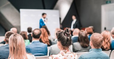 İş konferansında ya da takım toplantısında sunum ve proje tartışması. Konferans salonundaki izleyiciler. İş ve Girişimcilik Sempozyumu