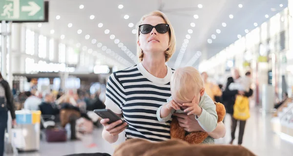 Anne Çocuğuyla Seyahat Ediyor Bebeğini Havaalanı Terminalinde Tutuyor Uçuş Saatlerini — Stok fotoğraf