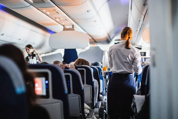 Wnętrze Samolotu Pasażerami Siedzeniach Stewardesą Mundurze Spacerującym Przejściu Służącym Ludziom — Zdjęcie stockowe