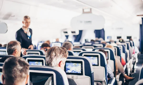 Wnętrze Samolotu Pasażerami Siedzeniach Stewardesą Mundurze Spacerującym Przejściu Służącym Ludziom — Zdjęcie stockowe