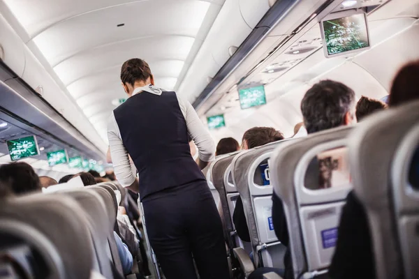 Interno Aeroplano Con Passeggeri Sui Sedili Hostess Uniforme Piedi Navata — Foto Stock