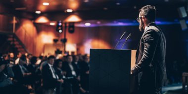 Sözcü şirket iş konferansı hakkında bir konuşma yapacak. Konferans salonundaki tanınmayan insanlar. İş ve Girişimcilik etkinliği.