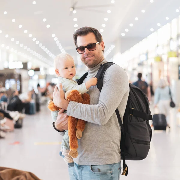 父亲带着孩子旅行 抱着他的男婴在机场候机楼等着登机 带孩子旅行的概念 — 图库照片