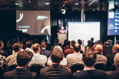 Sözcü, iş konferansında konferans salonunda konuşma yapacak. Konferans salonundaki tanınmayan insanların arka görüntüsü. İş ve girişimcilik kavramı