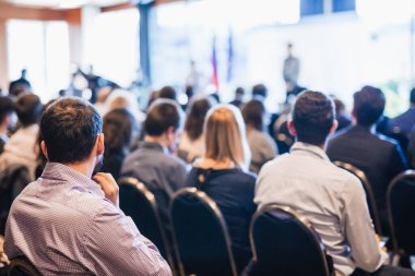 Sözcü, iş konferansında konferans salonunda konuşma yapacak. Konferans salonundaki tanınmayan insanların arka görüntüsü. İş ve girişimcilik kavramı