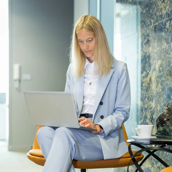 一位漂亮的女商人坐在桌旁 在笔记本电脑上工作 现代办公环境中的时尚女性 — 图库照片