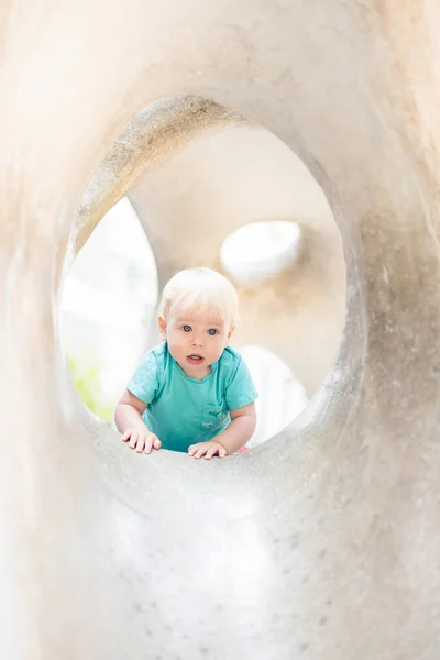 stock image Child playing on outdoor playground. Toddler plays on school or kindergarten yard. Active kid on stone sculpured slide. Healthy summer activity for children. Little boy climbing outdoors