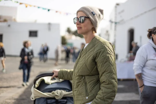 西班牙兰雅罗特市Tequise大街上穿着绿色棉衣 毛帽和太阳镜的年轻时尚女子的画像 — 图库照片