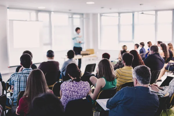 İş ve girişimcilik sempozyumu. Sözcü iş toplantısında bir konuşma yapacak. Konferans salonunda dinleyiciler. İzleyicilerin tanınmayan katılımcılarının arka görünümü.