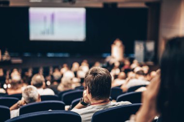 Konuşmacı bilimsel konferans hakkında bir konuşma yapacak. Konferans salonundaki izleyiciler. İş ve Girişimcilik kavramı
