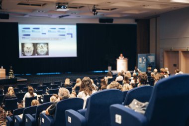 Konuşmacı bilimsel konferans hakkında bir konuşma yapacak. Konferans salonundaki izleyiciler. İş ve Girişimcilik kavramı