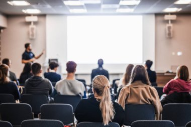 Sözcü, iş konferansında konferans salonunda konuşma yapacak. Konferans salonundaki tanınmayan insanların arka görüntüsü. İş ve girişimcilik kavramı
