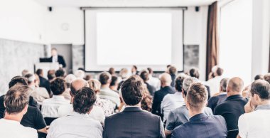 Sözcü, iş konferansında konferans salonunda konuşma yapacak. Konferans salonundaki izleyiciler. İş ve Girişimcilik konsepti. Seyirciler arasındaki tanınmayan kişilere odaklanın..