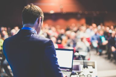 Sözcü şirket iş konferansı hakkında bir konuşma yapacak. Konferans salonundaki tanınmayan insanlar. İş ve Girişimcilik etkinliği.