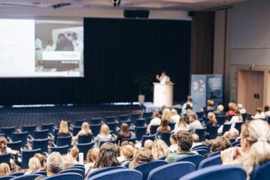 Konuşmacı bilimsel konferans hakkında bir konuşma yapacak. Konferans salonundaki izleyiciler. İş ve Girişimcilik kavramı