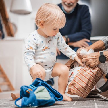 Noel 'i ya da doğum günü hediyesini açan tatlı sarışın, beyaz çocuk. Sevimli küçük bebek erkek bebek açılış hediyesi.